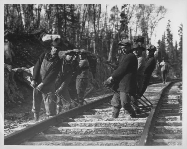 Huit hommes posant les rails du chemin de fer de Rouyn-Noranda